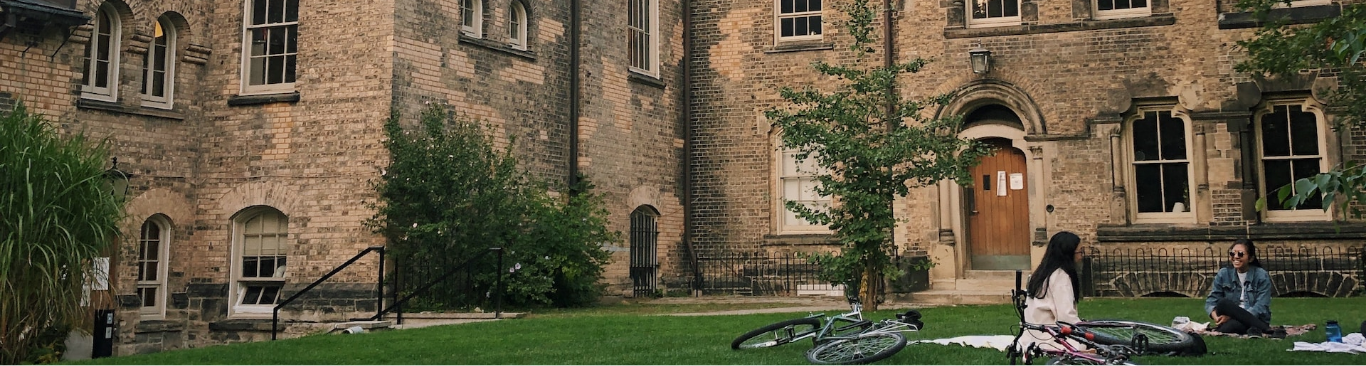 University of Toronto Campus. Person sitting on a blanket in the grass.