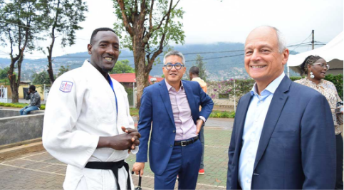 President Meric Gertler and Vice President International Joseph Wong standing and smiling with a man dressed in a martial arts uniform wearing a black belt. 
